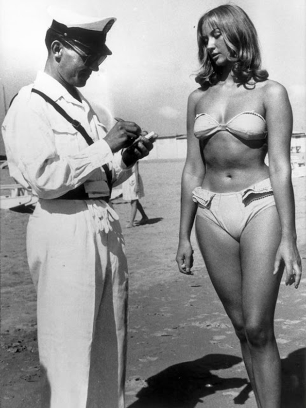 a-police-officer-issuing-a-woman-a-ticket-for-wearing-a-bikini-on-a-beach-at-rimini-italy-in-1957
