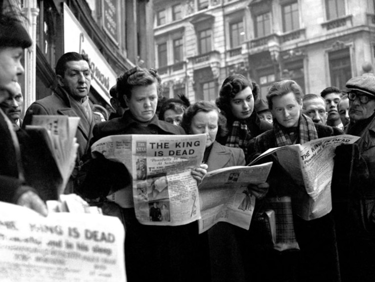 a group of people read newspapers