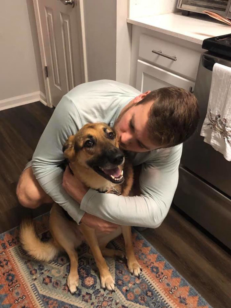 man hugging dog