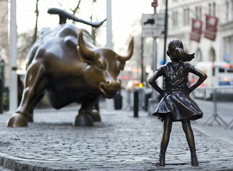 girl standing up to wall street bull statue