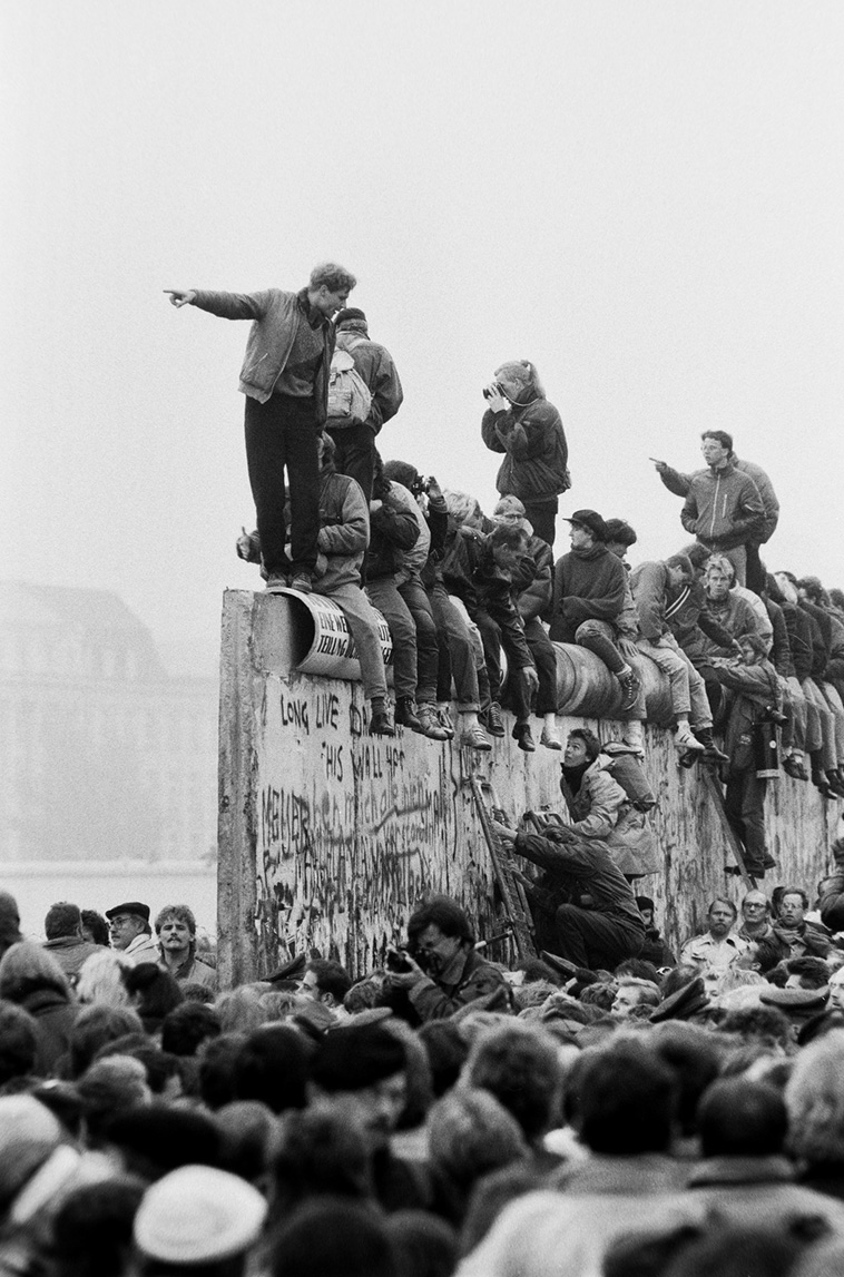 people getting over Berlin wall one of the most famous walls in recent history